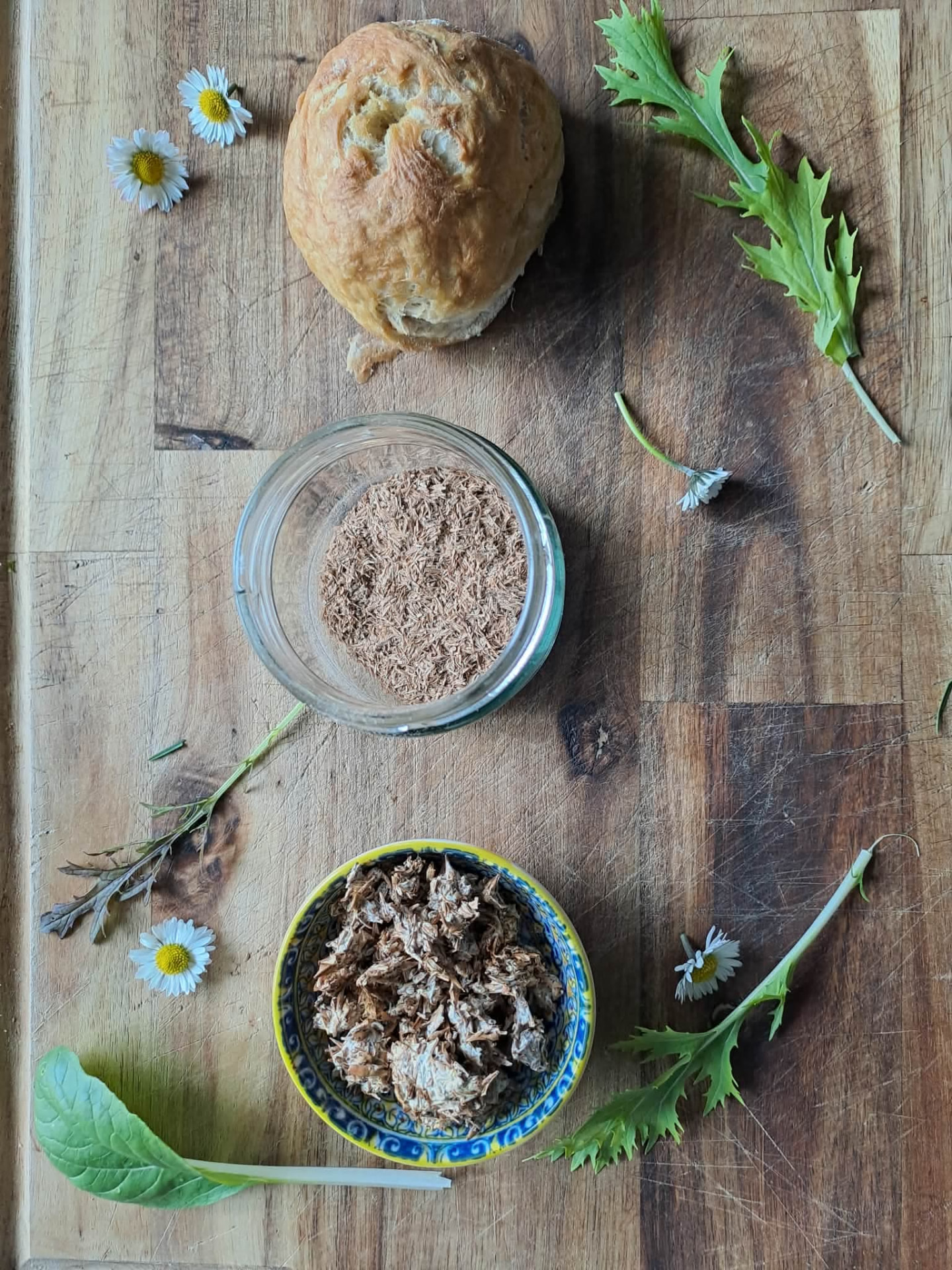 Bread baked with upcycled ingredients next to bowls of fermented spent grain